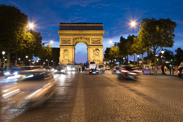 Champs Elysees and Arc de Triomphe in Paris, France. Night scene with car traffic.