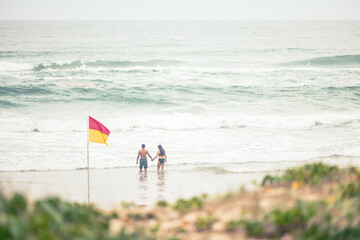 Obraz premium Man and woman couple holding hands in the water at Main Beach, Surfers Paradise Australia