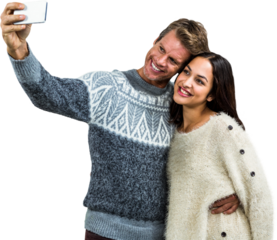 Cheerful young couple wearing warm clothing taking selfie