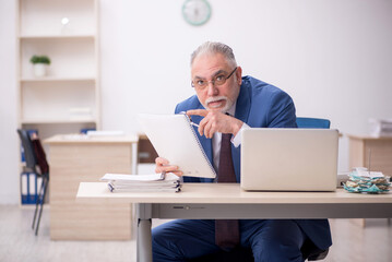 Old male employee working in the office