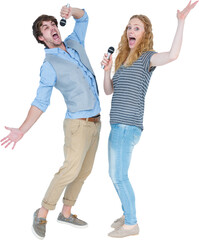 Happy couple singing into microphones