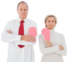 Older couple standing holding broken pink heart