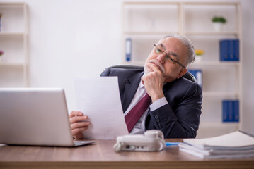 Naklejka premium Old male employee and too much work in the office