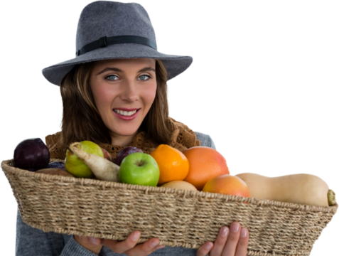 Portrait of young woman carrying fruits and vegetables in basket