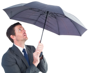 Businessman sheltering under black umbrella