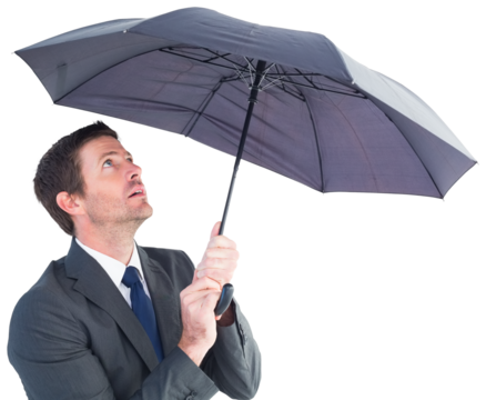 Businessman sheltering under black umbrella