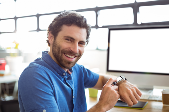 Portrait of smiling business executive adjusting smartwatch