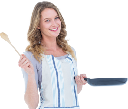 Smiling woman holding frying pan and wooden spoon 