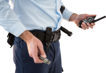 Mid section of security officer holding walkie talkie and hand cuff