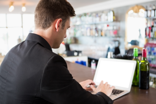 Rear view of businessman typing on laptop