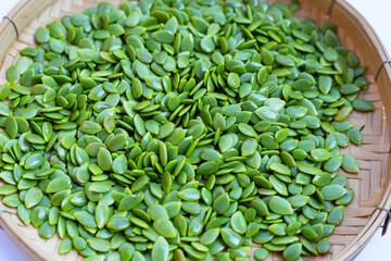 Leucaena leucocephala seeds in bamboo weave plate on white background