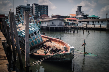 Fototapeta na wymiar A wrecked fishing boat moored at Bang Saray Pier, Sattahip District, Thailand.