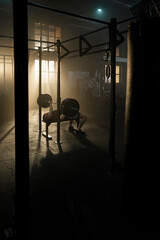 Full shot of a young adult strong man doing bench barbell at gym. Athlete with muscular body doing...