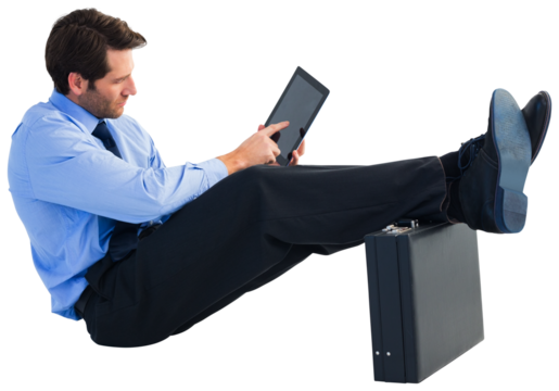 Businessman sitting on the floor with feet up on suitcase