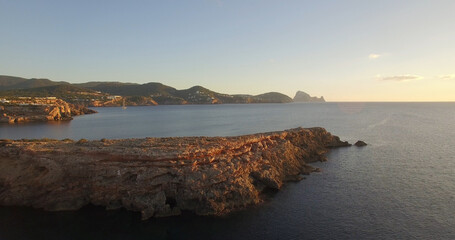 Fototapeta premium Rock formations by sea during sunset