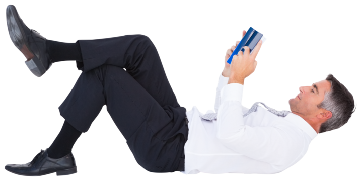 Businessman reading book while lying on white background