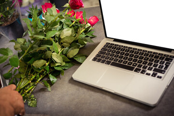 Laptop by flower on table