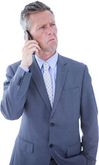Confused businessman talking on mobile phone