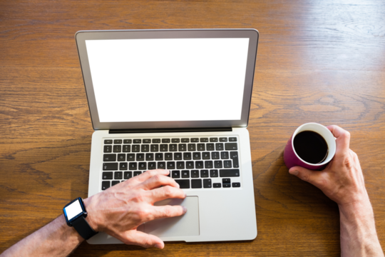 Man using laptop and holding coffee cup