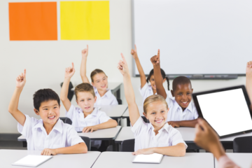 School kids raising hand in classroom