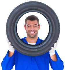 Happy mechanic looking through tire