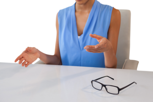 Mid section of businesswoman gesturing while sitting at table