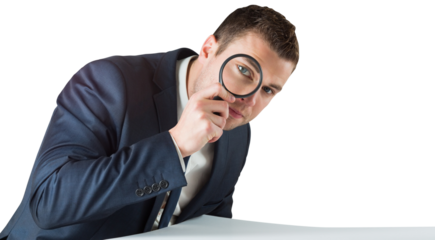 Businessman looking through magnifying glass