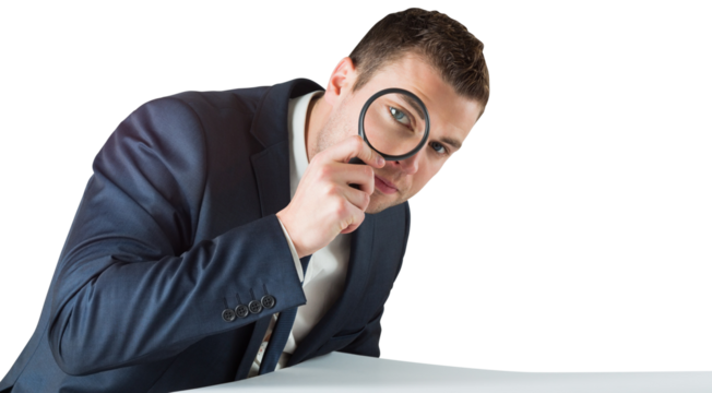 Businessman looking through magnifying glass