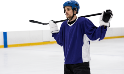 Hockey player with hockey stick standing on rink