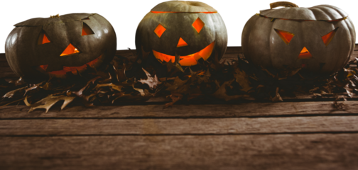 High angle view of jack o lanterns with leaves on table