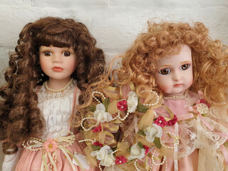 two porcelain dolls with long curly hair