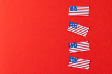 High angle view of four flags of united states of america with copy space on red background