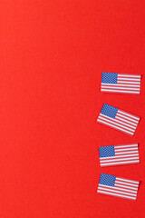 Obraz premium High angle view of four flags of united states of america with copy space on red background