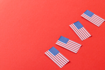 Fototapeta na wymiar High angle view of four flags of united states of america with copy space on red background