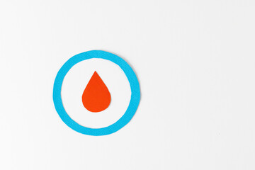 Blood drop in blue ring on white background with copy space