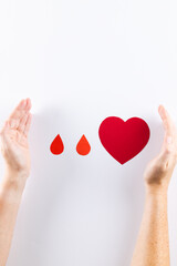 Hands of caucasian woman protecting blood drops and heart on white background, with copy space
