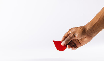 Hand of biracial man holding blood drop, on white background with copy space