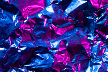 Close up of crumpled and shiny multi coloured foil with copy space