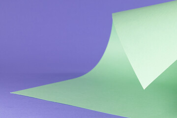 Close up of green paper on purple background with copy space