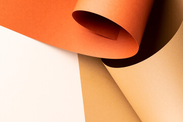 Close up of orange and beige paper on white background with copy space
