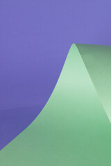 Close up of green paper on purple background with copy space