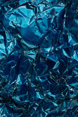 Close up of crumpled and shiny blue foil with copy space