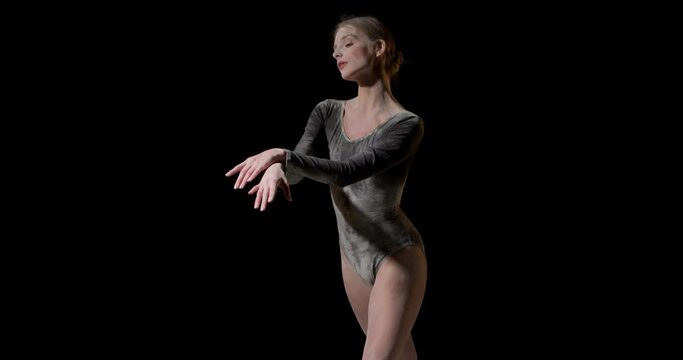 Dancing in flour concept.Beautiful caucasian female woman dancer in dust, fog wearing black bodysuit, making dance element in flour cloud on isolated black studio background, moves arms smoothly