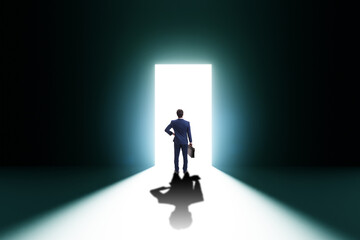 Businessman entering backlit door in escape concept