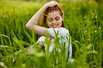 beautiful woman enjoying nature sitting in tall grass