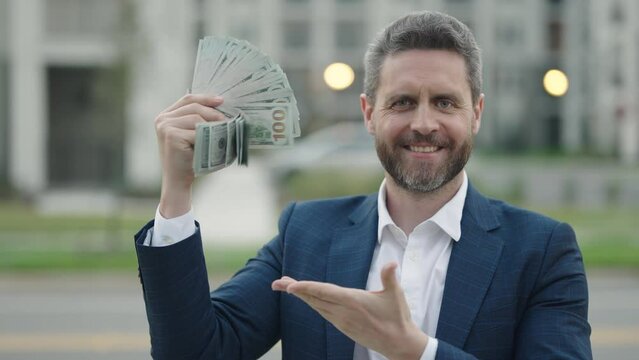 Portrait business man holding cash dollar bills outdoor. Big luck, banner. Dollar cash money concept. Rejoices to win cash. Man hold cash money. Financial luck and success.