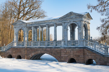 View of the ancient Marble bridge in the Catherine park of Tsarskoye Selo on a sunny February day....