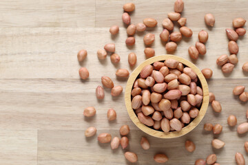 Top view of peanuts in a bowl on wooder background, Healthy eating concept