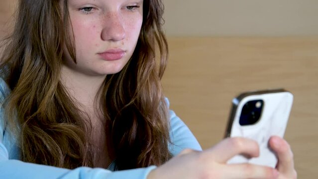 Teen Uses Her Smartphone While She Waits For Public Transportation, Someone Purchases A Ticket In Background. High quality