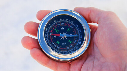 Close-up of a male hand holding a beautiful compass